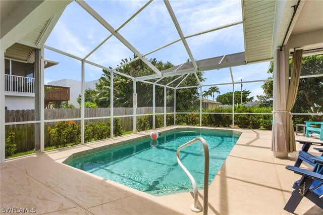 view of pool featuring glass enclosure and a patio area