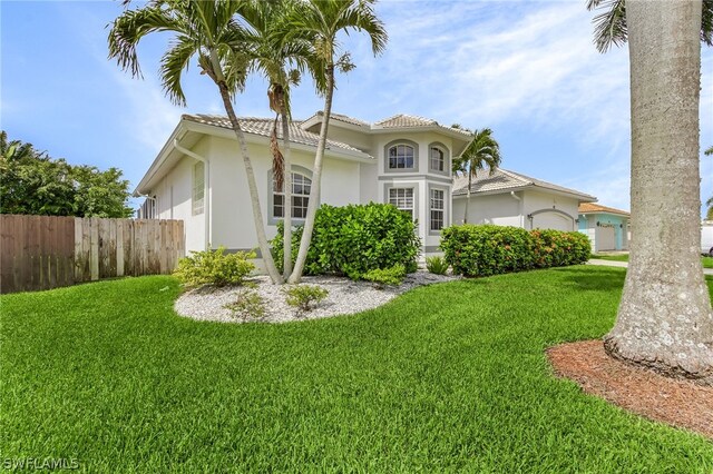 mediterranean / spanish house with a front yard and a garage