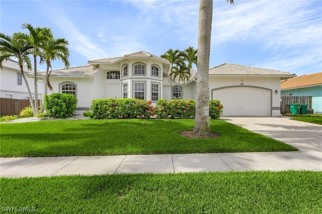 mediterranean / spanish home with a garage and a front lawn