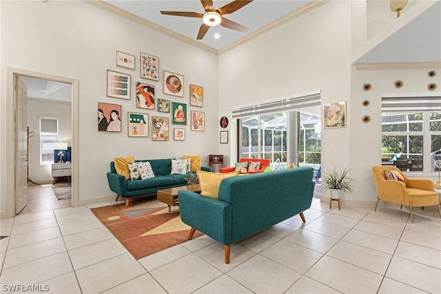 living room featuring light tile patterned flooring, a towering ceiling, plenty of natural light, and ceiling fan