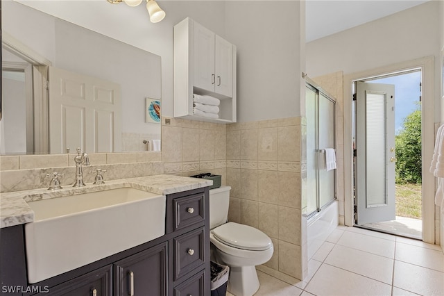 full bathroom with tile patterned floors, vanity, tile walls, and toilet