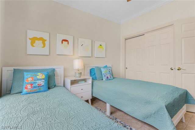 tiled bedroom featuring crown molding and a closet