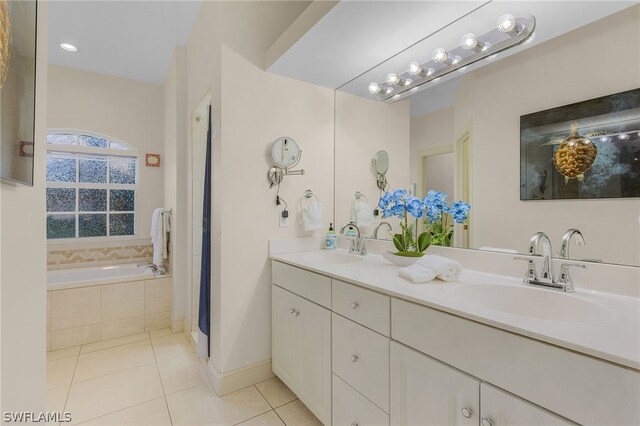 bathroom with vanity, tile patterned flooring, and a relaxing tiled tub