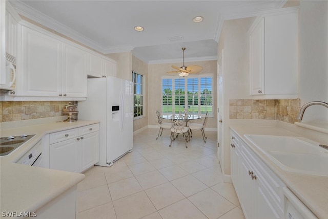 kitchen with white appliances, decorative light fixtures, white cabinetry, sink, and light tile patterned floors