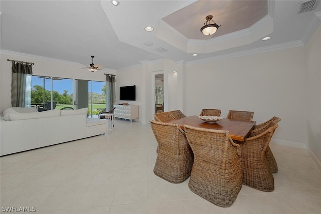 dining area with ceiling fan, a raised ceiling, ornamental molding, and light tile patterned floors