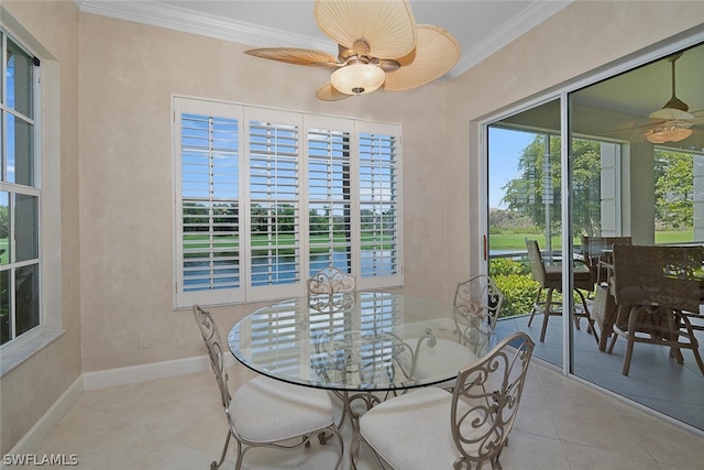 tiled dining room with ceiling fan and ornamental molding