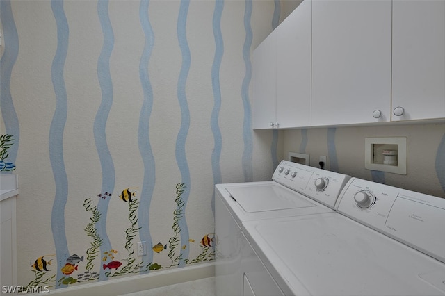 clothes washing area featuring cabinets and independent washer and dryer