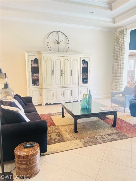 living room featuring a tray ceiling, light tile patterned floors, and ornamental molding