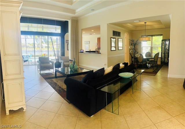 tiled living room with a tray ceiling, crown molding, and plenty of natural light