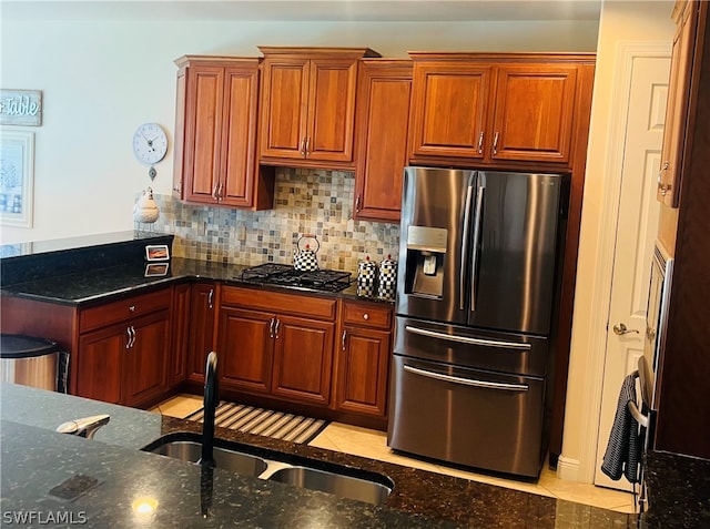 kitchen with dark stone countertops, light tile patterned flooring, and stainless steel refrigerator with ice dispenser