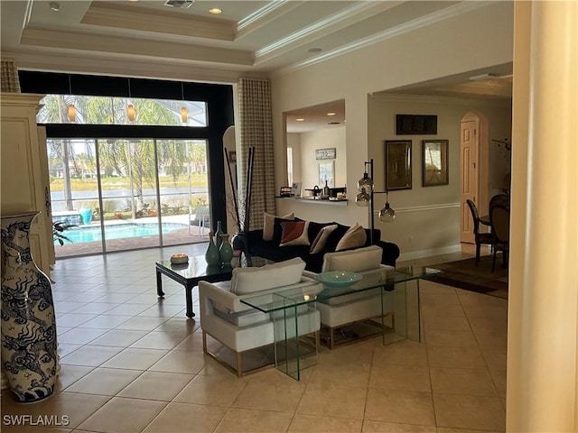 tiled living room with a towering ceiling, ornamental molding, and a tray ceiling