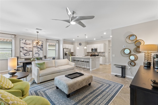 living room featuring ceiling fan, sink, and ornamental molding