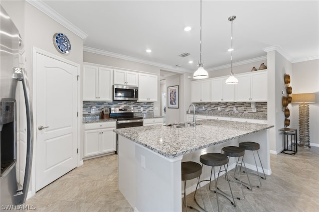 kitchen with white cabinets, a kitchen island with sink, appliances with stainless steel finishes, and sink