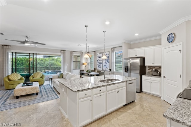 kitchen featuring white cabinetry, ceiling fan, a kitchen island with sink, hanging light fixtures, and sink