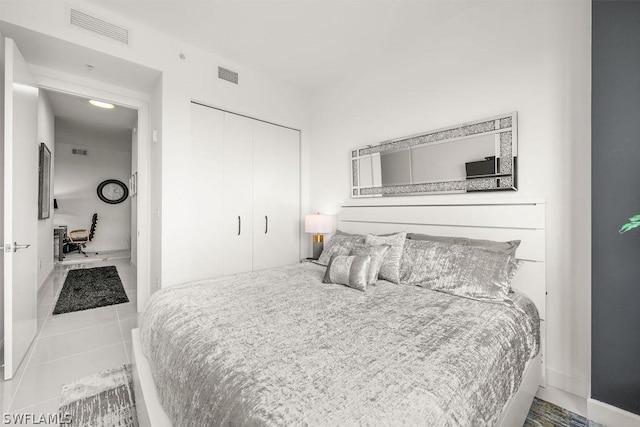 bedroom with a closet, visible vents, and tile patterned floors