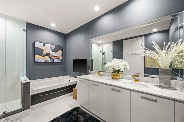 bathroom with recessed lighting, a sink, a shower stall, a bath, and double vanity