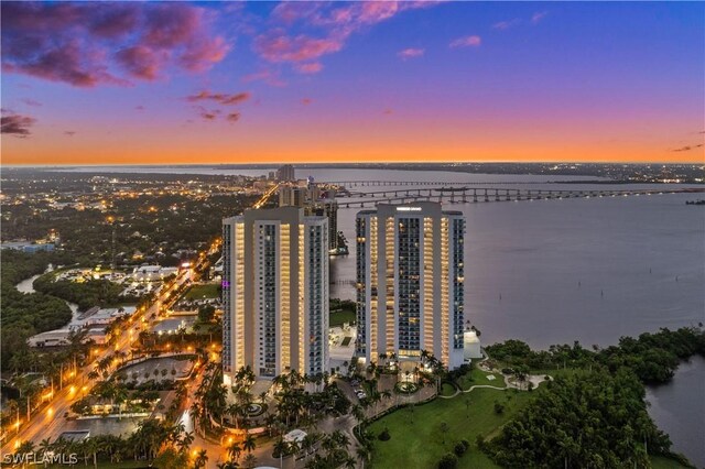 aerial view at dusk featuring a water view