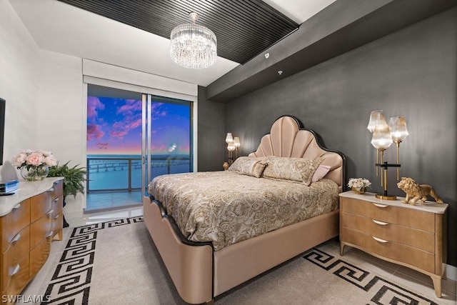 bedroom featuring access to exterior and an inviting chandelier