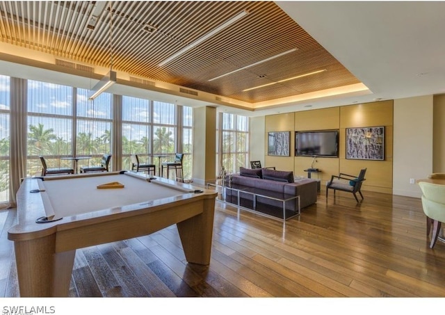 rec room featuring a raised ceiling, visible vents, expansive windows, billiards, and hardwood / wood-style floors