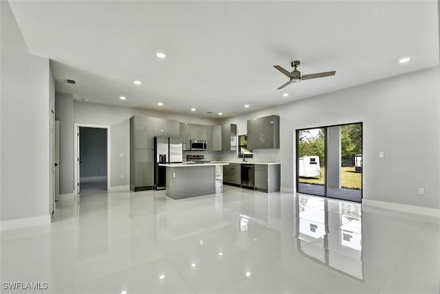 kitchen featuring modern cabinets, gray cabinetry, a kitchen island, appliances with stainless steel finishes, and light countertops