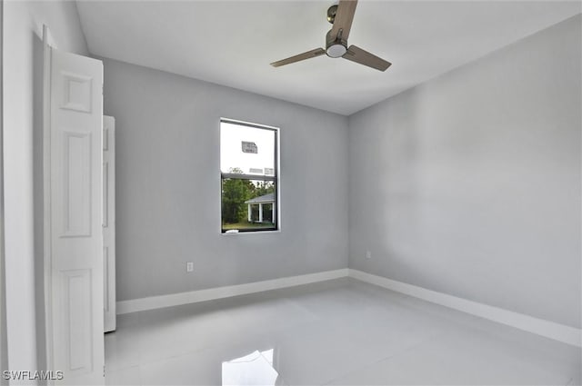 unfurnished room with a ceiling fan and baseboards