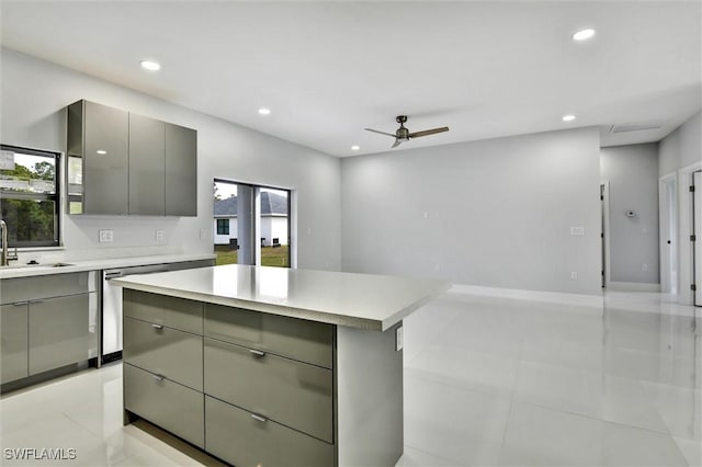 kitchen featuring gray cabinets, a kitchen island, stainless steel dishwasher, recessed lighting, and light countertops