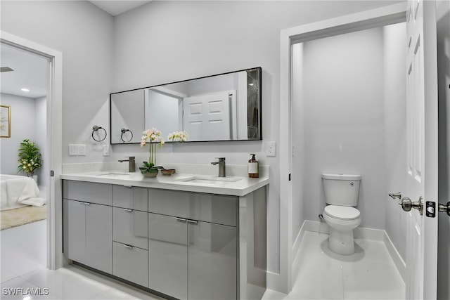 full bathroom featuring double vanity, tile patterned floors, toilet, and a sink