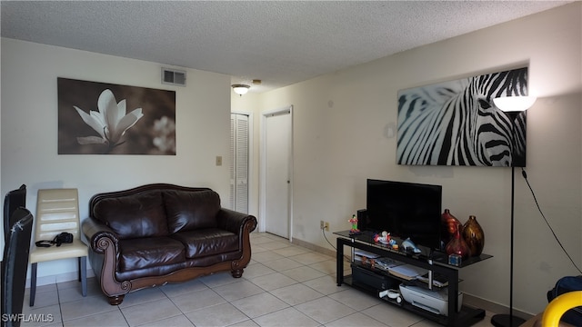 living room featuring a textured ceiling and light tile patterned flooring