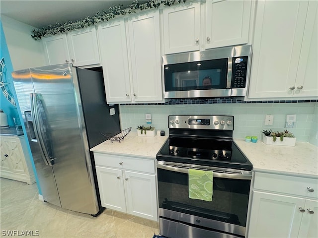 kitchen with appliances with stainless steel finishes, white cabinets, and light stone countertops