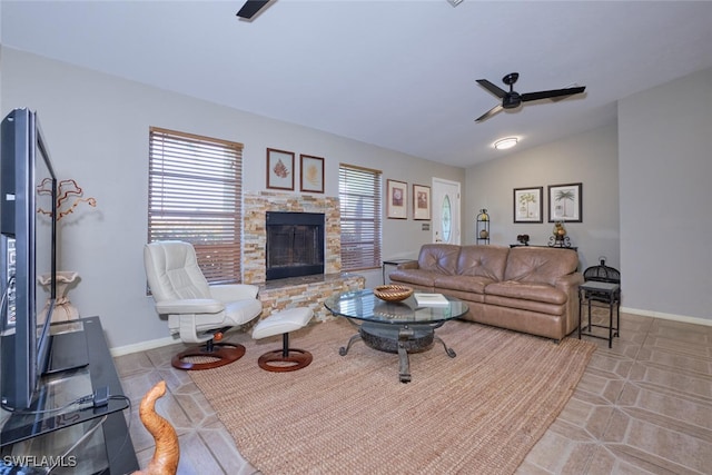 living room with a stone fireplace, lofted ceiling, and ceiling fan