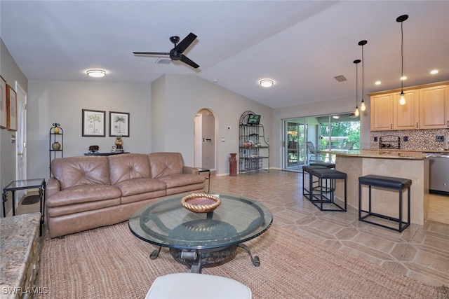 living room with ceiling fan, vaulted ceiling, and light tile patterned floors