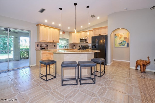 kitchen featuring black appliances, lofted ceiling, decorative backsplash, and plenty of natural light