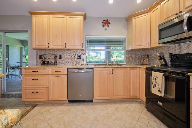 kitchen with sink, light tile patterned flooring, plenty of natural light, and stainless steel appliances