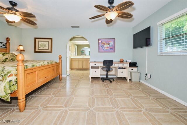 bedroom featuring light tile patterned flooring, ensuite bath, and ceiling fan