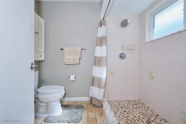 bathroom featuring curtained shower, toilet, and tile patterned floors