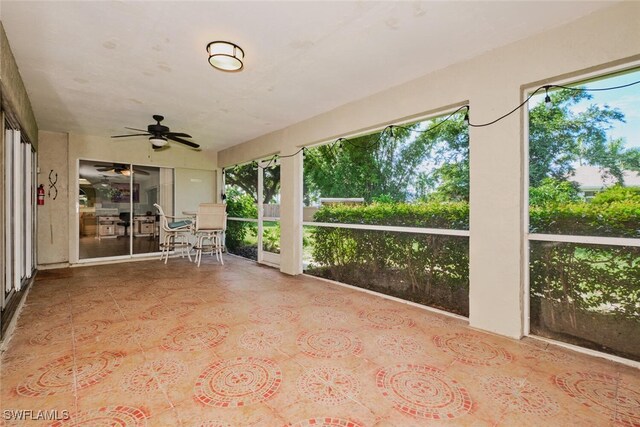 unfurnished sunroom with a wealth of natural light and ceiling fan