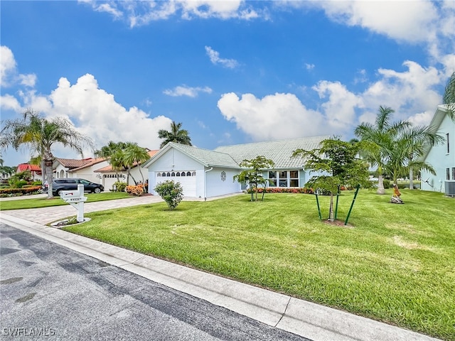 single story home with central air condition unit, a garage, and a front yard