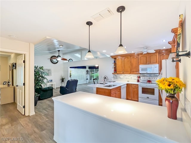 kitchen featuring sink, kitchen peninsula, light hardwood / wood-style flooring, dishwasher, and electric range