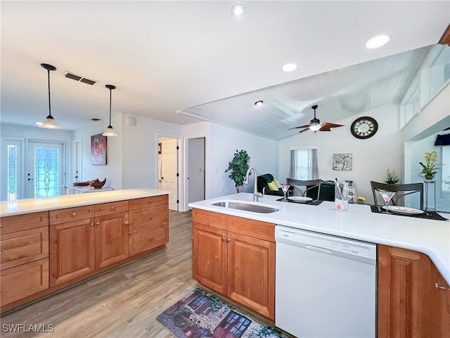 kitchen featuring sink, white dishwasher, hanging light fixtures, light wood-type flooring, and vaulted ceiling