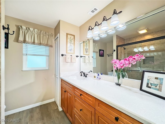 bathroom with toilet, an enclosed shower, vanity, and wood-type flooring