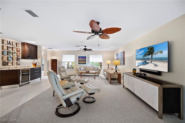 tiled living room with ceiling fan and wine cooler