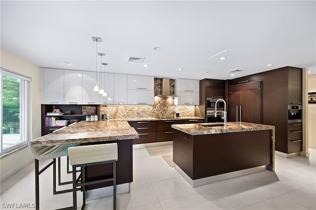 1303 Wahoo Ct, Naples, FL 34102 - kitchen featuring modern cabinets, dark brown cabinets, paneled fridge, white cabinetry, and backsplash