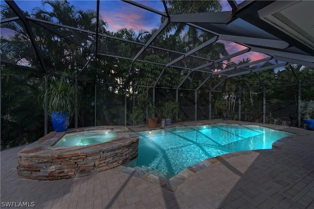 1303 Wahoo Ct, Naples, FL 34102 - pool at dusk featuring a patio area, a lanai, and a pool with connected hot tub