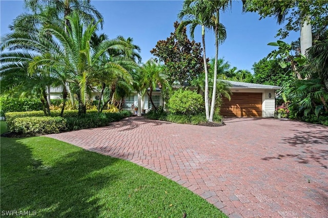 1303 Wahoo Ct, Naples, FL 34102 - view of front of home featuring decorative driveway, a garage, and a front lawn