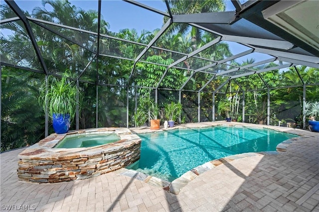 view of pool with a lanai, a patio area, and an in ground hot tub