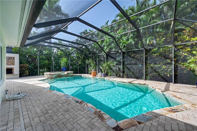 view of pool featuring a lanai, an in ground hot tub, and a patio