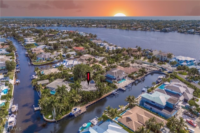 aerial view at dusk featuring a water view