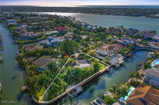 aerial view at dusk featuring a water view