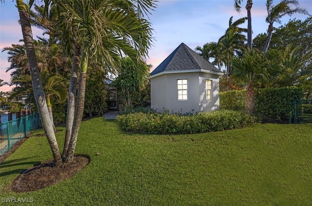 property exterior at dusk with a lawn