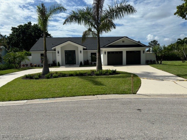 single story home with a garage and a front lawn